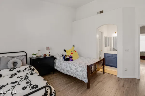 a bedroom with a bed and wooden floor