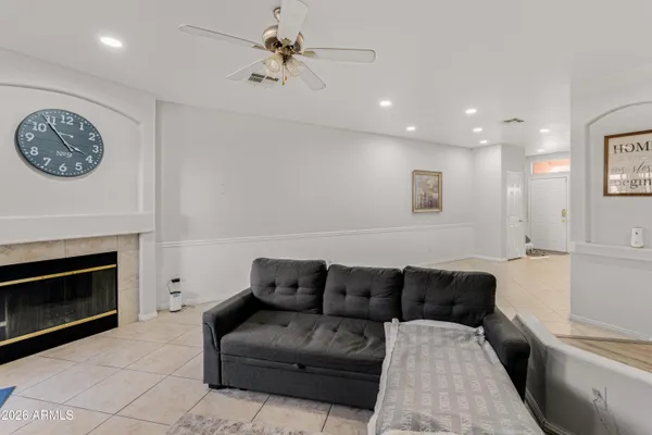 a living room with furniture a clock and a fireplace
