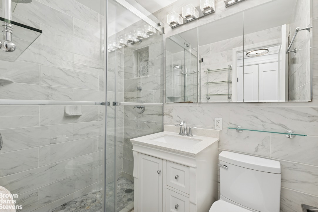 330 3rd Avenue, Unit 10B Manhattan, NY 10010 - Photo 7 of 14 a bathroom with a sink a toilet and shower