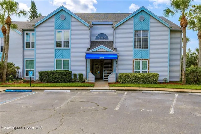 a front view of a house with a yard and potted plants