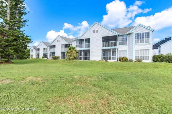 a view of a house with a big yard and large trees