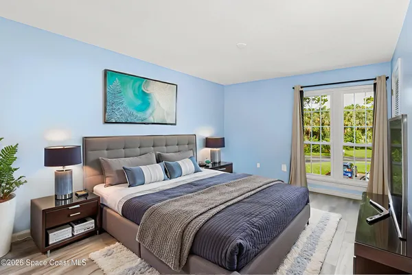 a bedroom with bed and a large window