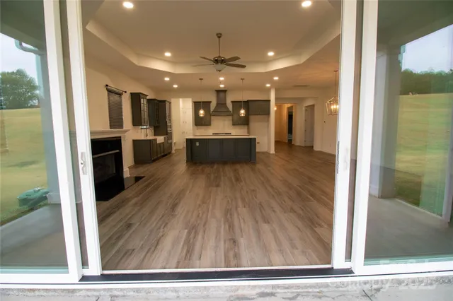 a view of a living room and a kitchen with wooden floor