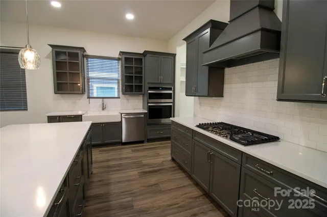 a kitchen with stainless steel appliances a stove cabinets and wooden floor