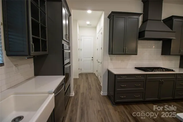 a kitchen with stainless steel appliances granite countertop a refrigerator and a stove top oven