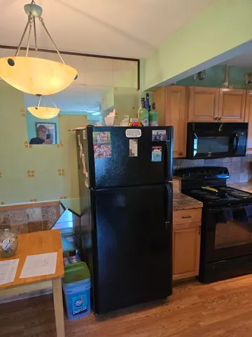 a kitchen with stainless steel appliances granite countertop a refrigerator and a stove