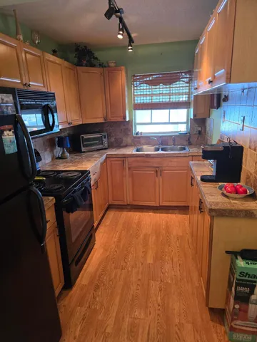 a kitchen with stainless steel appliances granite countertop a stove a sink dishwasher and a microwave oven with cabinets