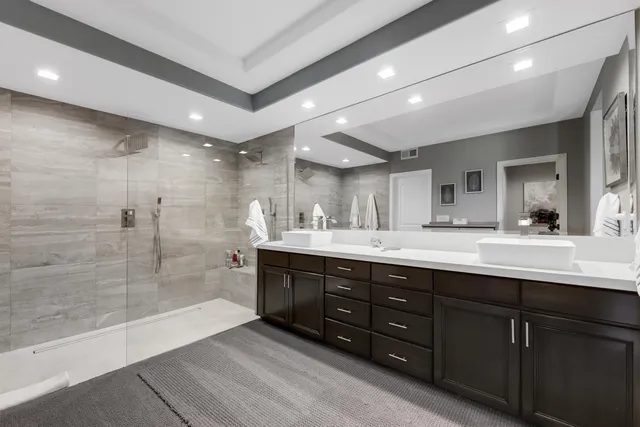a bathroom with a sink mirror and a shower