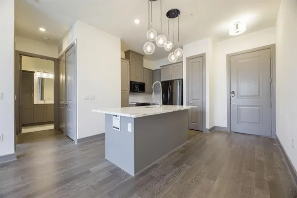 a large kitchen with stainless steel appliances a large center island and cabinets