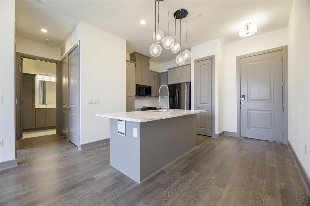 a large kitchen with stainless steel appliances a large center island and cabinets