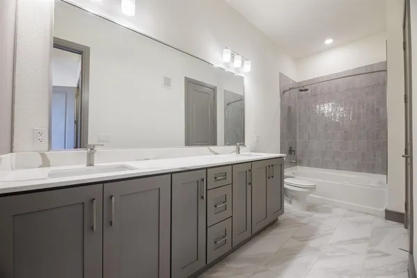 a bathroom with double sink and a mirror