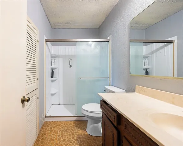 a bathroom with a sink a toilet and shower
