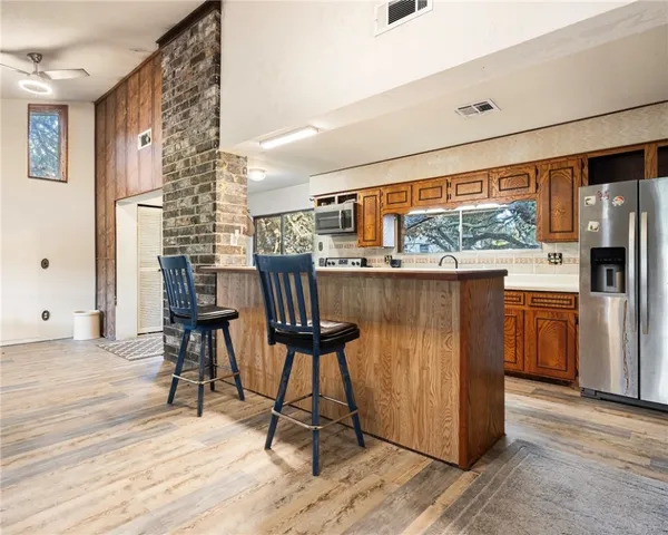 a dining hall with stainless steel appliances granite countertop a stove and a refrigerator