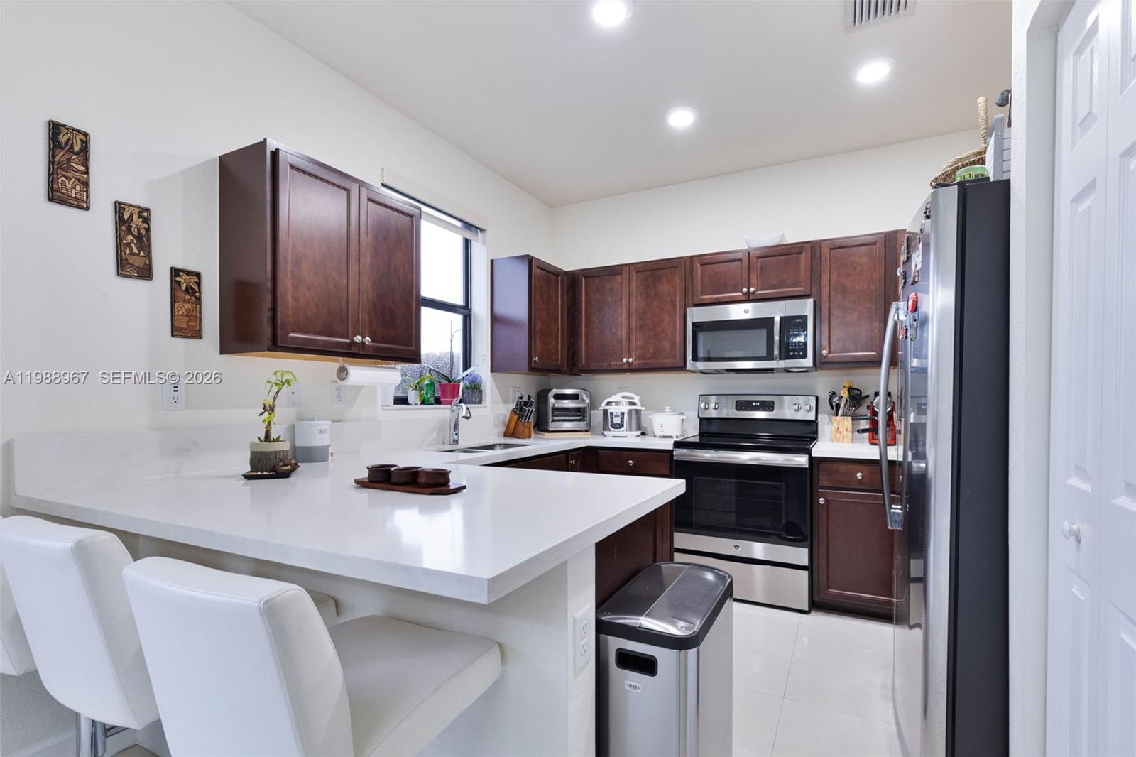 9015 Northwest 183rd Street Hialeah, FL 33018 - Photo 11 of 45 a kitchen with stainless steel appliances a sink a stove a refrigerator cabinets and a counter space