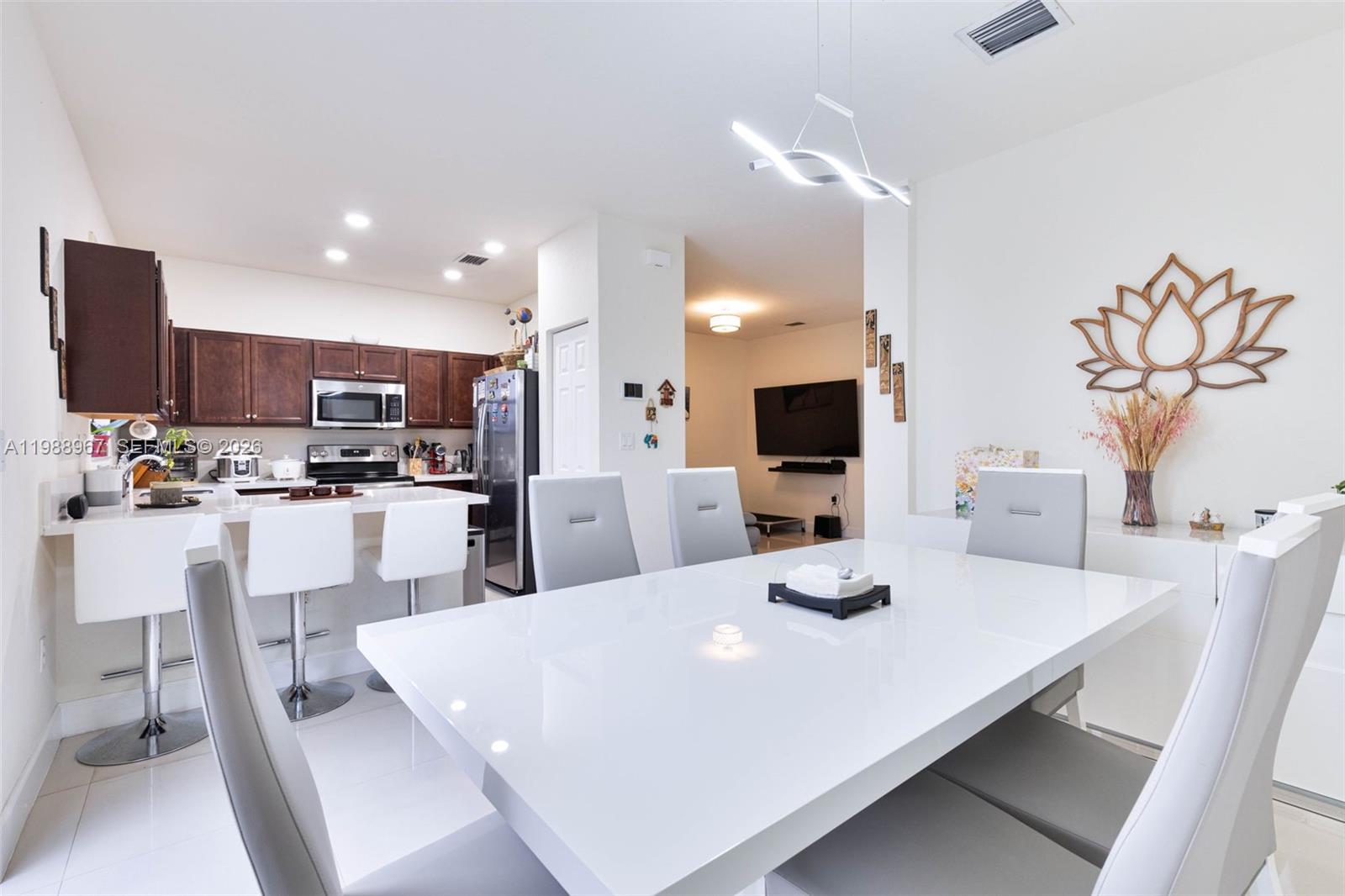9015 Northwest 183rd Street Hialeah, FL 33018 - Photo 15 of 45 a kitchen with kitchen island stainless steel appliances a sink and white cabinets