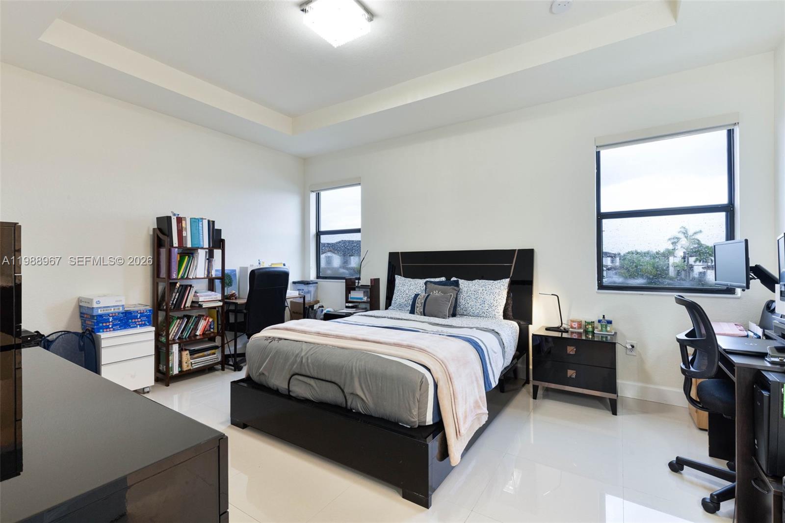 9015 Northwest 183rd Street Hialeah, FL 33018 - Photo 16 of 45 a bedroom with a bed a table and large windows