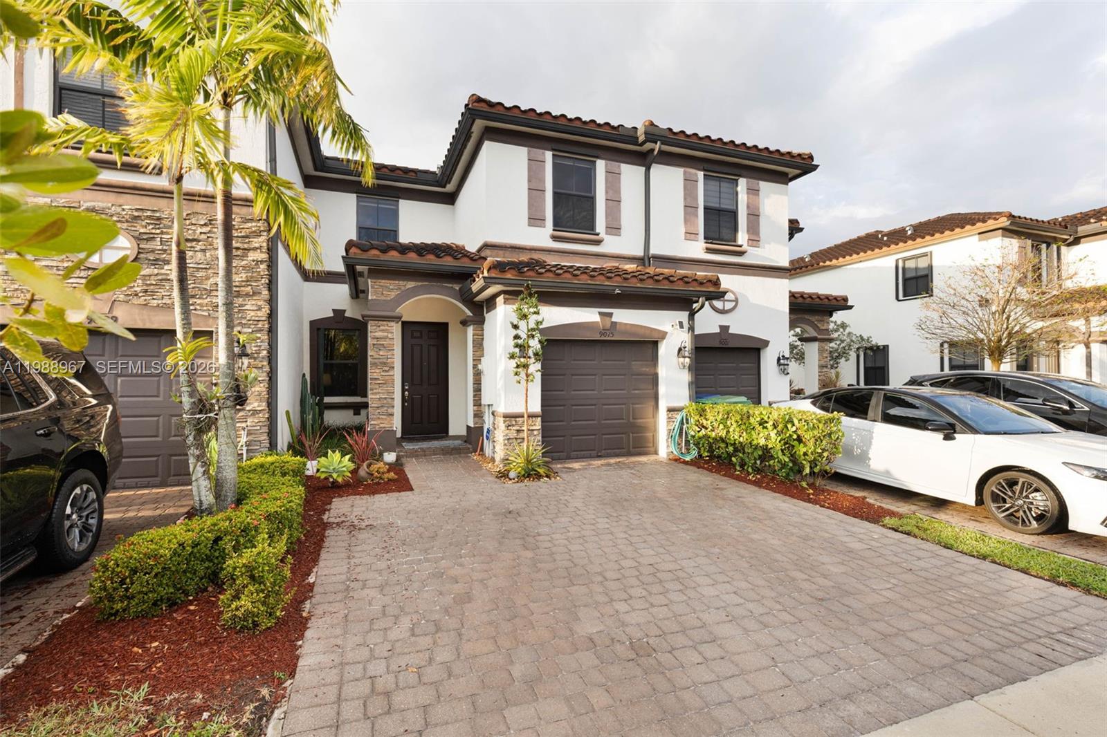 9015 Northwest 183rd Street Hialeah, FL 33018 - Photo 2 of 45 a front view of a house with a yard and garage