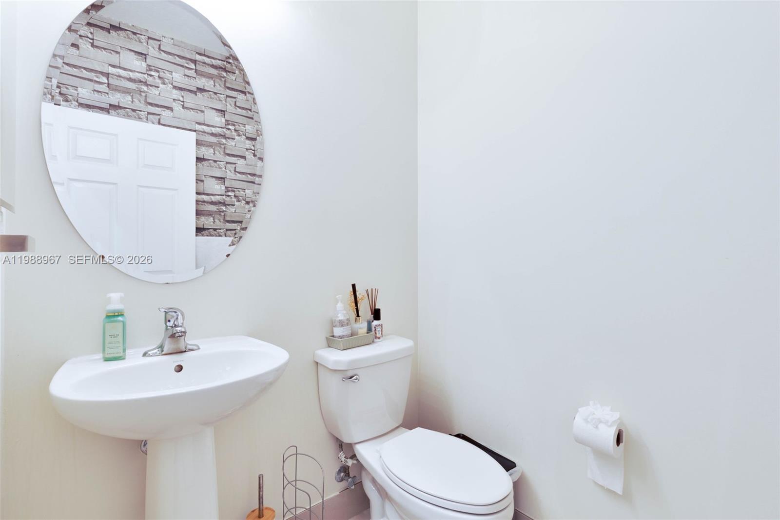 9015 Northwest 183rd Street Hialeah, FL 33018 - Photo 8 of 45 a bathroom with a sink a toilet and mirror