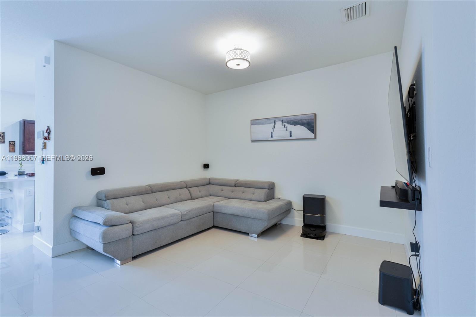 9015 Northwest 183rd Street Hialeah, FL 33018 - Photo 10 of 45 a living room with furniture and a flat screen tv