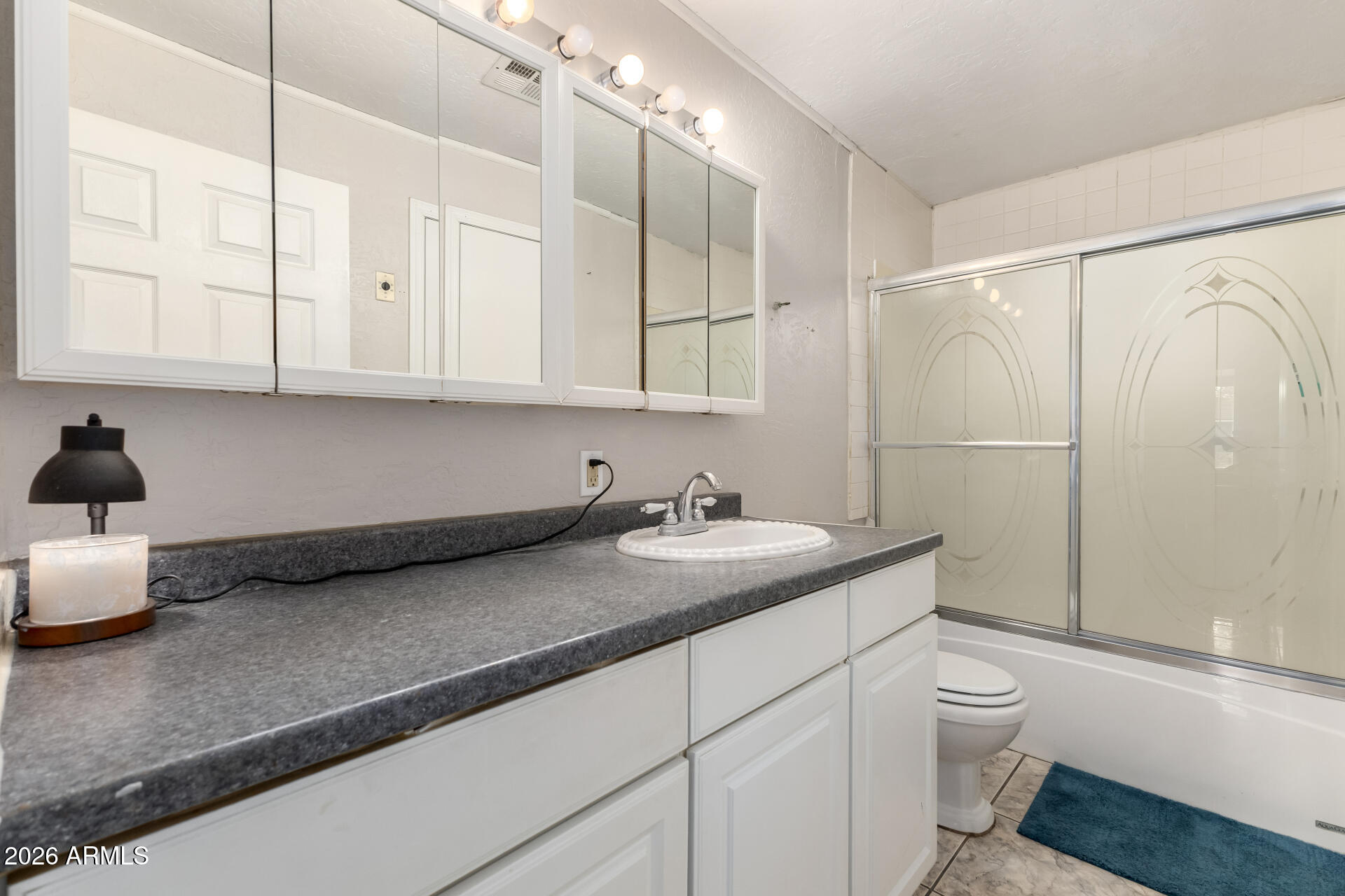 4032 West Nancy Lane Phoenix, AZ 85041 - Photo 18 of 29 a bathroom with a granite countertop sink a toilet and shower