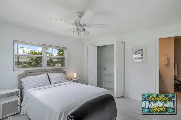 a bedroom with a bed and painting on the wall