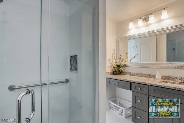 a bathroom with a granite countertop sink and a mirror