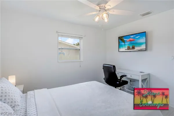 a bedroom with a bed and a painting on the wall