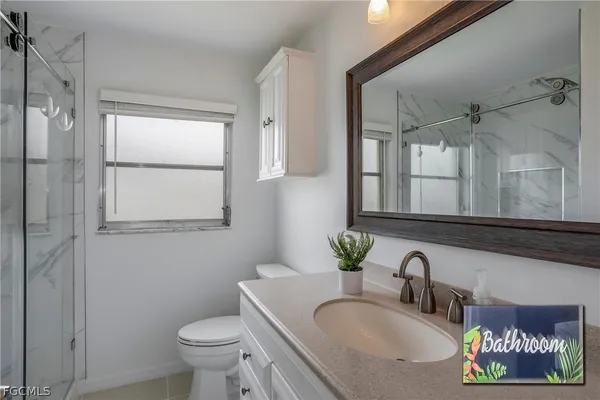 a bathroom with a granite countertop sink toilet and a mirror