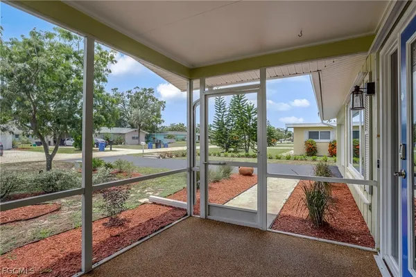 a view of a porch with a floor to ceiling window next to a yard