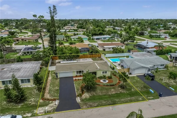an aerial view of residential houses with outdoor space and trees
