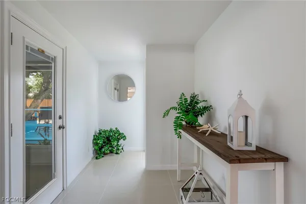 a view of a hallway with wooden floor and a potted plant