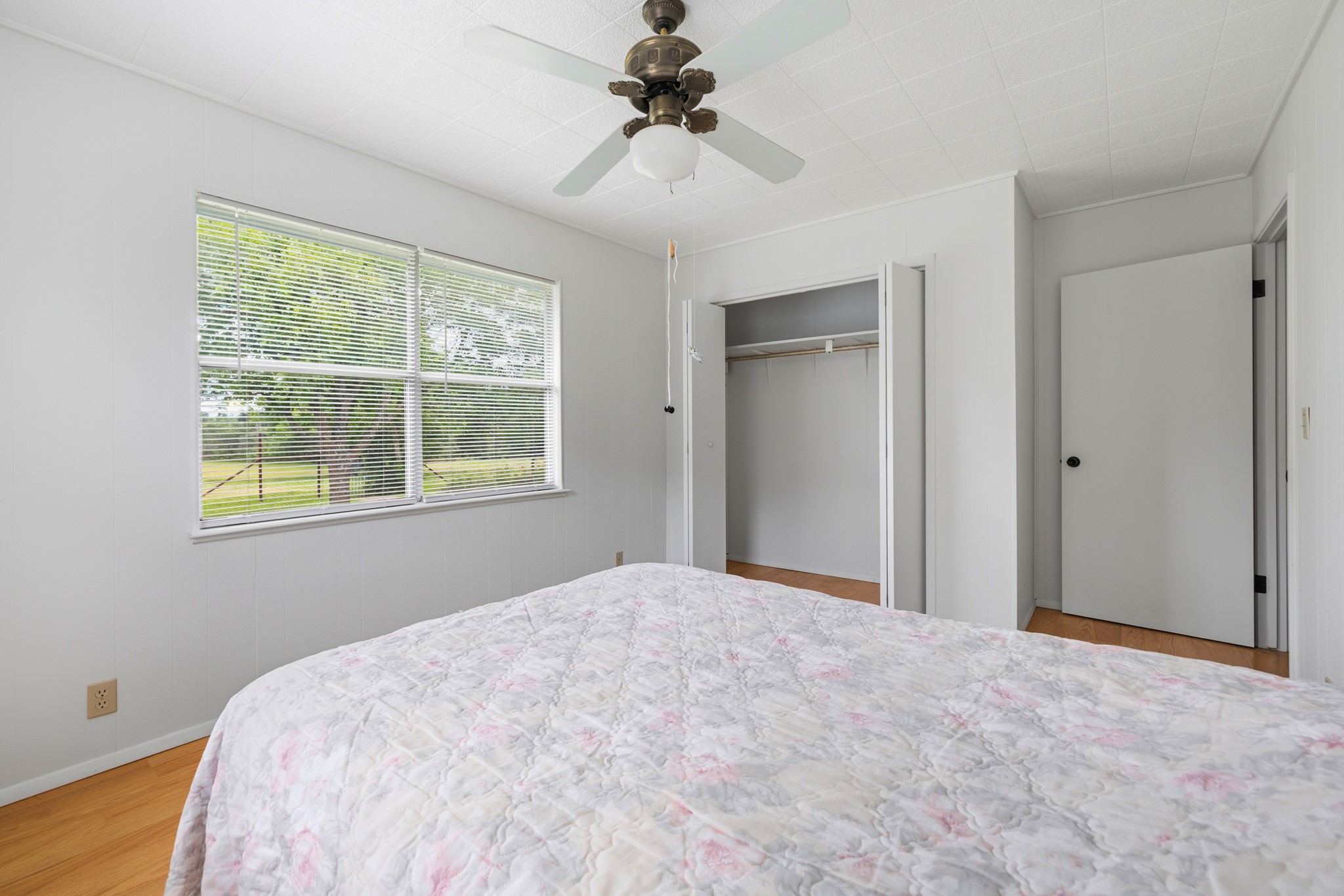 341 River View Road Fredericksburg, TX 78624 - Photo 22 of 40 Natural light fills this bedroom featuring warm hardwood flooring and a functional closet setup.
