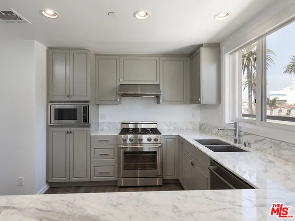 a kitchen with stainless steel appliances granite countertop a sink and stove top oven