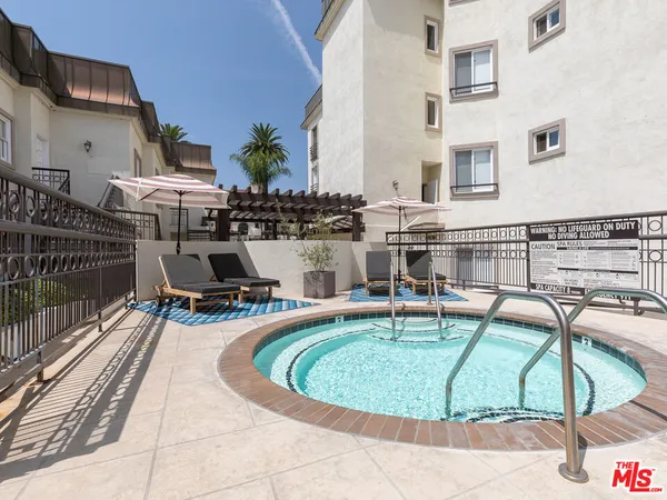 a view of a swimming pool with chairs and backyard