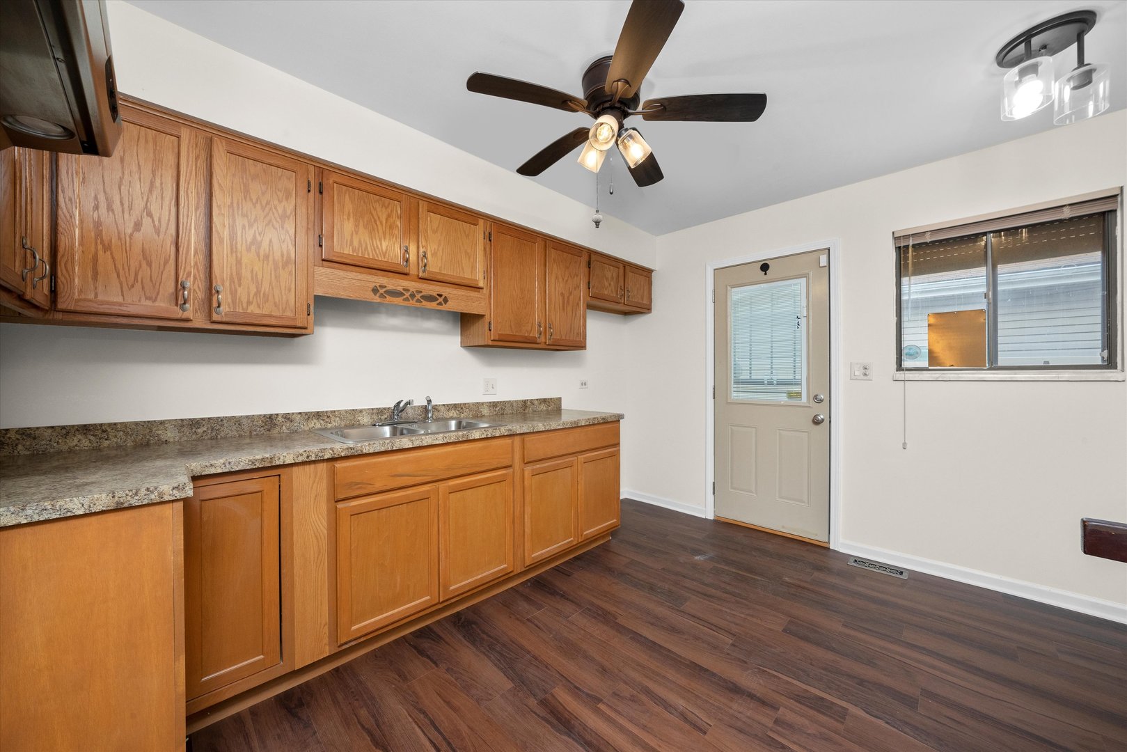 18057 Juneway Court Country Club Hills, IL 60478 - Photo 14 of 36 a kitchen with granite countertop wooden floors white cabinets and stainless steel appliances