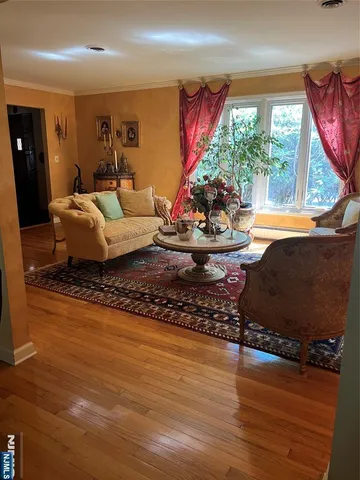 a living room with furniture floor to ceiling window and a wooden floor