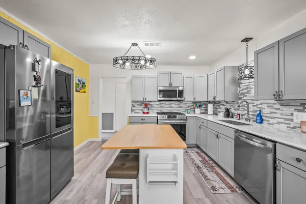 a kitchen with stainless steel appliances a refrigerator sink and cabinets