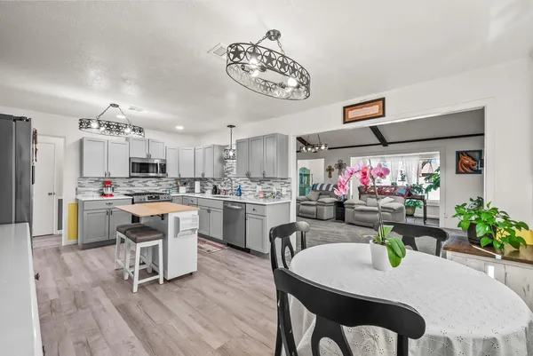 a kitchen with white cabinets stainless steel appliances and dining table