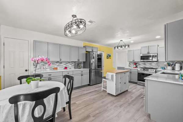 a kitchen with a table chairs stove and cabinets