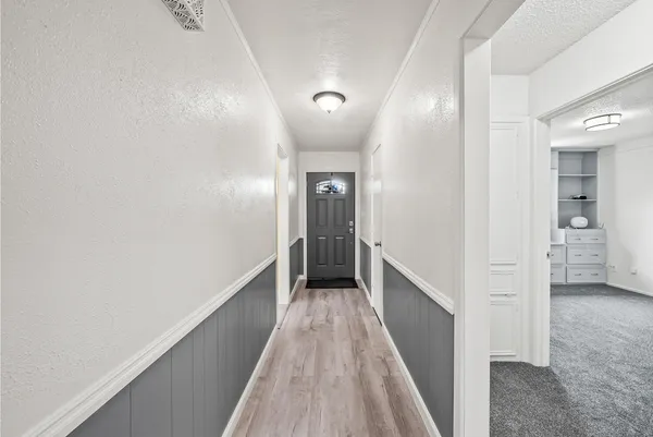 a view of a hallway with wooden floor