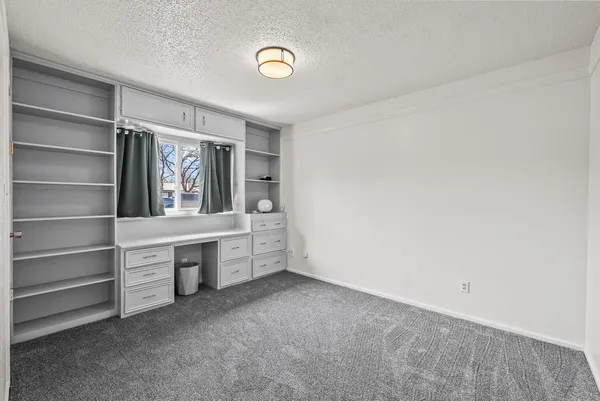 a view of an empty room with cabinet and a window