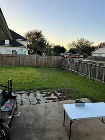 a view of a yard with wooden fence and a fence