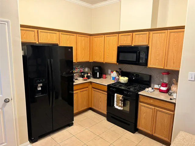 a kitchen with stainless steel appliances granite countertop a refrigerator and a stove top oven