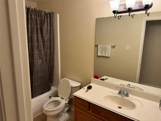 a bathroom with a sink a toilet a mirror and shower curtain