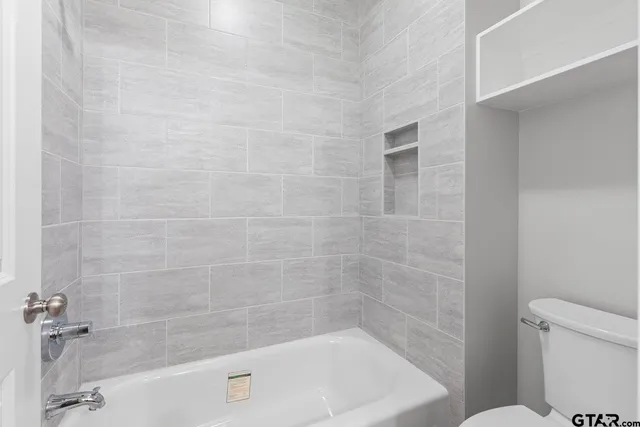 a bath tub sitting next to a white toilet