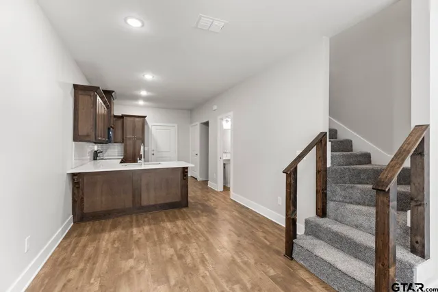 a view of kitchen with sink wooden floor and window