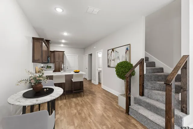 a living room with furniture potted plant and kitchen view