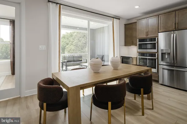 a kitchen with stainless steel appliances granite countertop a table chairs and wooden floor