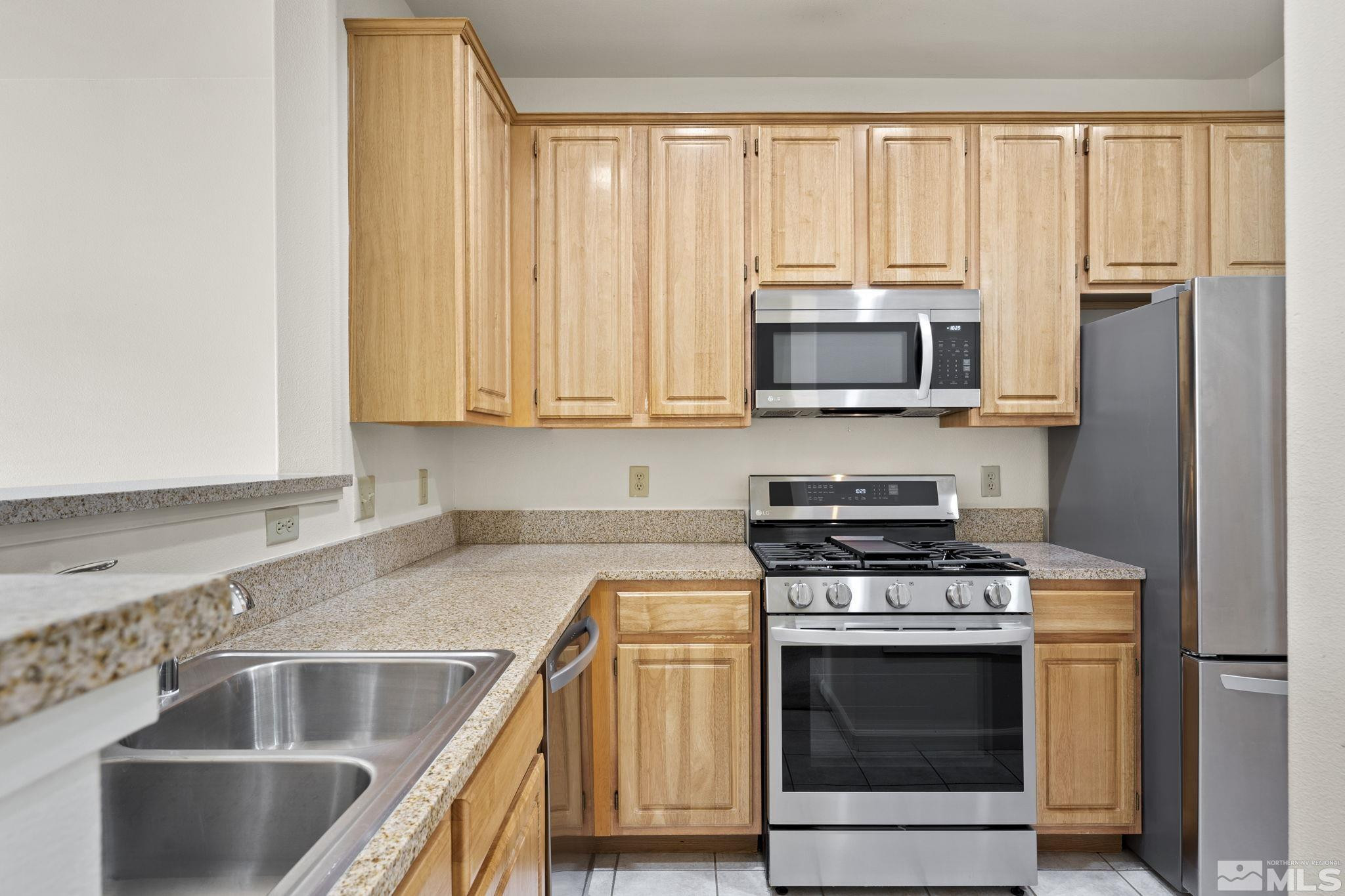 900 South Meadows Parkway, Unit 3423 Reno, NV 89521 - Photo 10 of 37 a kitchen with stainless steel appliances granite countertop a stove microwave and cabinets
