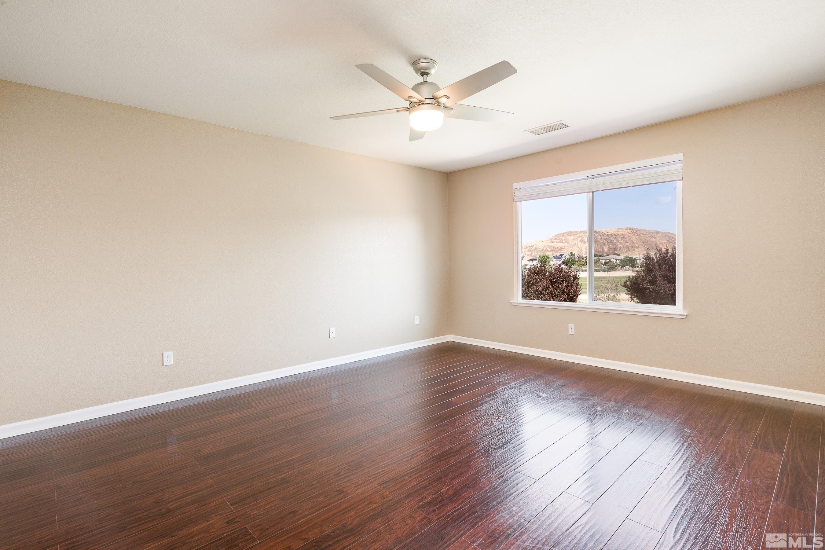 1955 Black Drive Reno, NV 89521 - Photo 15 of 40 an empty room with wooden floor chandelier fan and windows